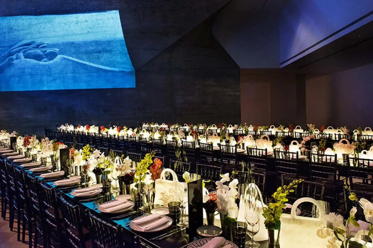 Opening event at the Tel Aviv Museum of Art, with the film projected across the hall above the wax bag centerpieces.