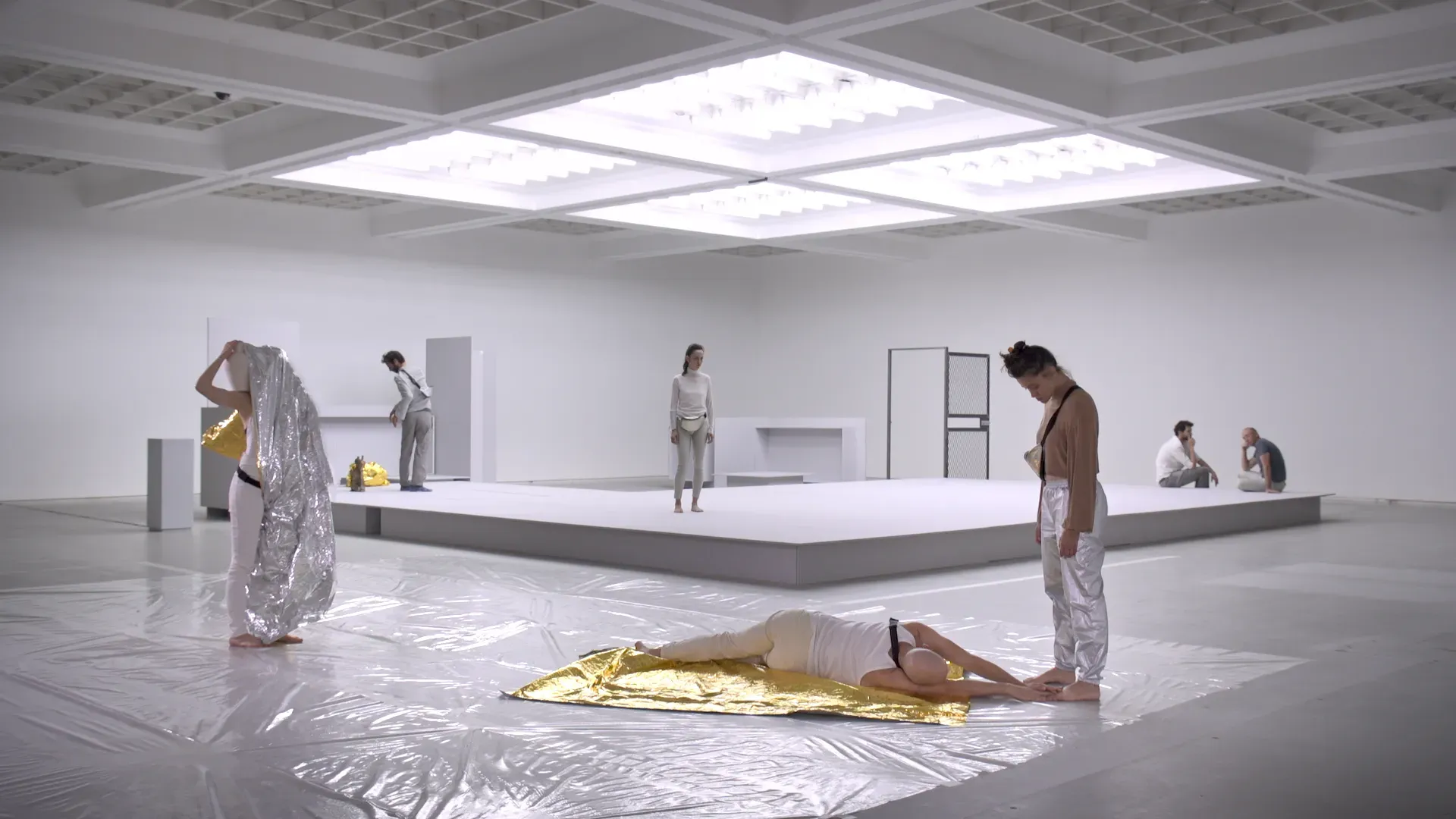 Video still showing the exhibition space and the white-box lighting design.